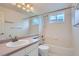 Clean, bright bathroom includes shower-tub combo and white tile walls at 5130 S Wenatchee St, Aurora, CO 80015