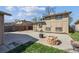 Spacious backyard with a concrete patio, wood fence, and fire pit, perfect for outdoor entertaining at 6690 Albion St, Commerce City, CO 80022