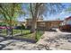 Home with a fenced yard, carport, and mature trees, offering shade and curb appeal at 6690 Albion St, Commerce City, CO 80022