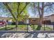 Charming single-story home with a brick facade, well-manicured lawn, and a wrought iron fence at 6690 Albion St, Commerce City, CO 80022