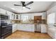 Bright kitchen featuring white cabinets, tile backsplash, stainless steel appliances, and tile flooring at 6690 Albion St, Commerce City, CO 80022