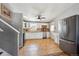 Open kitchen with white cabinets, stainless appliances, tiled floor and countertop plus large refrigerator at 6690 Albion St, Commerce City, CO 80022