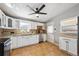 Functional kitchen with white cabinetry, neutral countertops, a ceiling fan and tiled flooring at 6690 Albion St, Commerce City, CO 80022