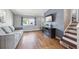 Inviting living room with hardwood floors, a large window, and a stylish entertainment center at 6690 Albion St, Commerce City, CO 80022