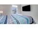Bright bedroom with large window, TV, and striped bedding at 28418 E 8Th Pl, Watkins, CO 80137