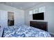 Main bedroom with dresser, TV, and blue floral bedding at 28418 E 8Th Pl, Watkins, CO 80137