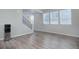 Bright living room with hardwood floors, three windows, and staircase at 28418 E 8Th Pl, Watkins, CO 80137