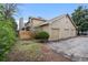 Tan home featuring a three car garage, chimney, wood fence, and foliage at 1080 S Yampa St, Aurora, CO 80017