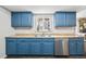 Well-equipped kitchen with blue cabinets, stainless steel dishwasher, and functional layout at 1080 S Yampa St, Aurora, CO 80017