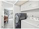 Bright laundry room featuring a modern washer and dryer with built-in white cabinets at 1080 S Yampa St, Aurora, CO 80017