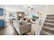 Open living room with a stone fireplace, neutral decor, and staircase at 1080 S Yampa St, Aurora, CO 80017