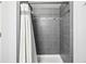 Updated shower stall with gray tiling and modern fixtures with a white shower curtain at 1080 S Yampa St, Aurora, CO 80017