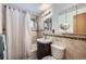 Bathroom with tiled walls, a sink with a wood cabinet, and a shower and tub behind a curtain at 1328 S Zuni St, Denver, CO 80223