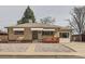 Charming single-story home with a brick facade, awnings, gravel yard, and a cozy front porch at 1328 S Zuni St, Denver, CO 80223