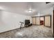 Spacious living room featuring a large TV, telescope, and beige carpet at 1328 S Zuni St, Denver, CO 80223