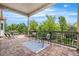 Spacious back porch with brick floors, overhead lighting, and views of mature trees at 14303 Glenayre Cir, Parker, CO 80134