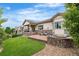 Beautiful backyard patio featuring a stone fire pit, lounge seating, manicured lawn, and mature trees at 14303 Glenayre Cir, Parker, CO 80134