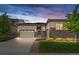 Charming single-Gathering home with stone accents, a manicured lawn, and a two-car garage at dusk at 14303 Glenayre Cir, Parker, CO 80134