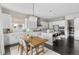 Open concept white kitchen with island, breakfast table and dark wood floors at 14303 Glenayre Cir, Parker, CO 80134
