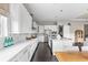 Bright kitchen featuring white cabinetry, stainless steel appliances, and dark hardwood floors at 14303 Glenayre Cir, Parker, CO 80134