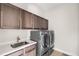 Laundry room with a sink, countertop and front-loading washer and dryer at 14303 Glenayre Cir, Parker, CO 80134