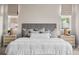 Close up on main bedroom featuring a padded headboard, side tables and neutral color scheme at 14303 Glenayre Cir, Parker, CO 80134