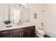 Bathroom featuring dark wood cabinets, double sinks, white countertop, toilet, and a shower-tub combo at 2038 S Columbine St, Denver, CO 80210