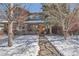 Charming two-story red brick home with a walkway dusted with snow leading to the front door at 2038 S Columbine St, Denver, CO 80210