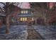 Charming two-story red brick home with walkway dusted with snow leading to the front door at twilight at 2038 S Columbine St, Denver, CO 80210