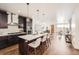Modern kitchen with quartz countertops, stainless steel appliances, a center island with bar stools, and pendant lights at 2038 S Columbine St, Denver, CO 80210
