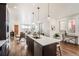 Bright, open kitchen with center island, modern pendant lights, and a view into the dining and living areas at 2038 S Columbine St, Denver, CO 80210