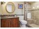 Bathroom featuring a glass-enclosed shower, vanity with sink, and a stylish round mirror at 6213 S Lima Way, Englewood, CO 80111