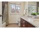 This bathroom features a neutral color palette, a dual sink vanity, and a window to the backyard at 6213 S Lima Way, Englewood, CO 80111