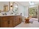 Bright bathroom boasting a double vanity, soaking tub, skylight, and private balcony with outdoor seating at 6213 S Lima Way, Englewood, CO 80111