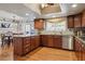 Well-lit kitchen featuring custom wood cabinets, hardwood floors, stainless steel appliances, and a center island at 6213 S Lima Way, Englewood, CO 80111