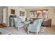 Comfortable seating area with a tufted sofa, accent chairs, elegant window treatments, and ample natural light at 6213 S Lima Way, Englewood, CO 80111