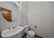 Bathroom featuring pedestal sink, round mirror and wood-look flooring at 8181 S Saint Paul Way, Centennial, CO 80122