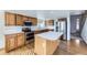 Well-lit kitchen with wood cabinets, stainless steel appliances, and a center island at 11676 Josephine Cir, Thornton, CO 80233