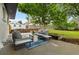 A modern back patio seating area featuring gray couches with blue and white rug at 5573 S Huron St, Littleton, CO 80120