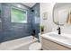 Modern bathroom featuring blue subway tile, updated fixtures, and natural light at 5573 S Huron St, Littleton, CO 80120