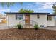 Charming single story home featuring a white painted brick exterior and a cozy front porch with black metal railings at 5573 S Huron St, Littleton, CO 80120