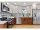 Modern kitchen with stainless steel appliances, contrasting cabinets, and a stylish backsplash enhancing the cooking space at 5573 S Huron St, Littleton, CO 80120