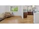 Open-concept living area with wood floors, large window, and stylish modern kitchen at 5573 S Huron St, Littleton, CO 80120