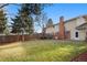 Large backyard with grassy area, mature trees, and patio furniture at 6631 E Ithaca Pl, Denver, CO 80237