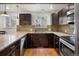 L-shaped kitchen with granite countertops and modern cabinetry at 6631 E Ithaca Pl, Denver, CO 80237