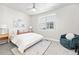 Bright bedroom with a queen bed and teal accent chair at 2828 N Federal Blvd, Denver, CO 80211