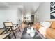 Open living room with a tan leather couch and wood chairs at 2828 N Federal Blvd, Denver, CO 80211