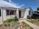 Inviting home entrance featuring red trim, garden, pathway, solar panels, and lush landscaping at 475 Tennyson St, Denver, CO 80204