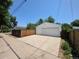 Detached garage with a wide driveway and white garage door, secured by a wooden fence at 475 Tennyson St, Denver, CO 80204