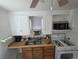Compact kitchen with double sink, gas range, and a microwave on shelves at 475 Tennyson St, Denver, CO 80204